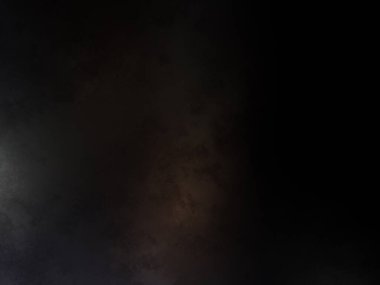 Takım elbiseli ve kravatlı bir adam karanlık bir arka planın önünde duruyor.