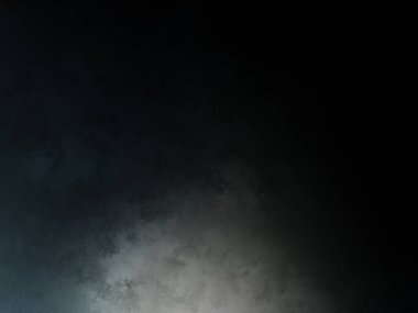 Siyah gömlekli bir adam tenis raketi tutuyor.