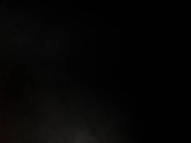 Takım elbiseli ve kravatlı bir adam mikrofonun önünde duruyor.