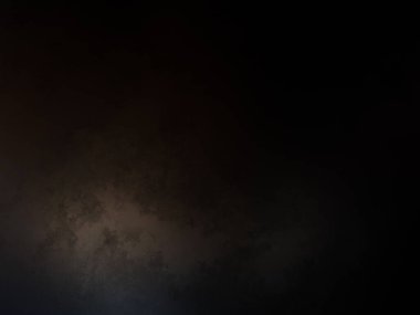 Takım elbiseli ve kravatlı bir adam karanlık bir arka planın önünde duruyor.