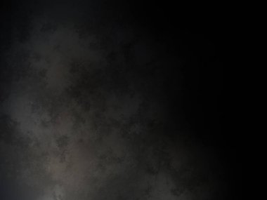 Siyah bir arka planın önünde duran takım elbiseli ve kravatlı bir adam.