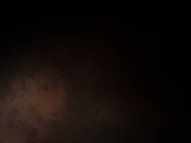 Takım elbiseli ve kravatlı bir adam karanlık bir arka planın önünde duruyor.