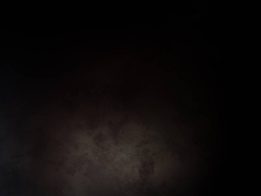 Siyah bir arka planın önünde duran takım elbiseli ve kravatlı bir adam.