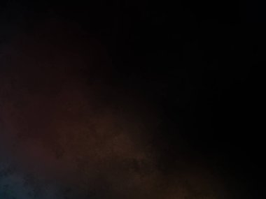 Siyah bir arka planın önünde duran takım elbiseli ve kravatlı bir adam.