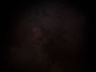 Takım elbiseli ve kravatlı bir adam karanlık bir arka planın önünde duruyor.