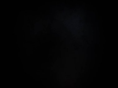 Siyah gömlekli bir adam elinde kamera tutuyor.