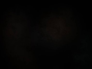 Siyah bir arka planın önünde duran takım elbiseli ve kravatlı bir adam.