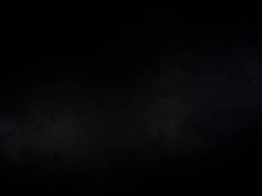 Siyah bir arka planın önünde duran takım elbiseli ve kravatlı bir adam.