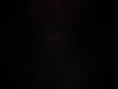 Karanlıkta cep telefonu olan biri.