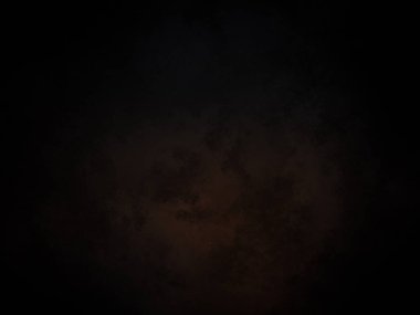 Karanlık bir gökyüzü, birkaç bulut ve bir uçak.