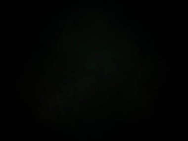 Karanlıkta elinde kamerayla bekleyen biri.