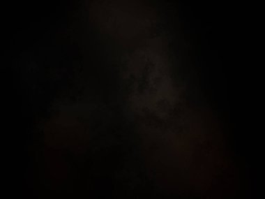 Siyah gömlekli bir adam cep telefonu tutuyor.