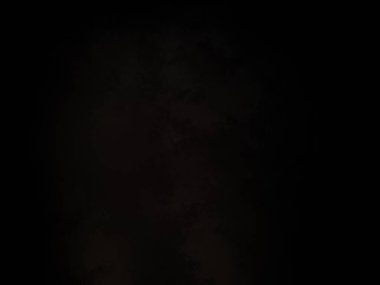 Karanlıkta elinde cep telefonu olan bir adam.