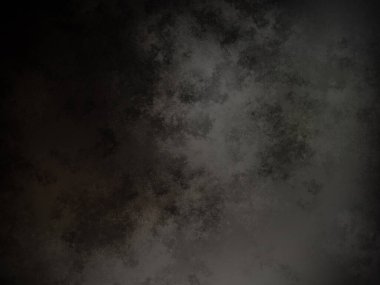 Siyah bir arka planın önünde duran takım elbiseli ve kravatlı bir adam.