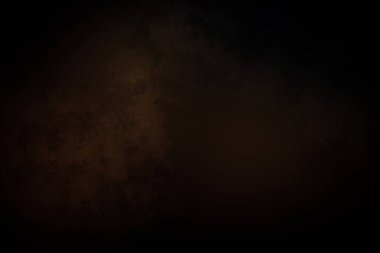 Takım elbiseli ve kravatlı bir adam karanlık bir arka planın önünde duruyor.