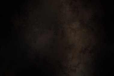 Siyah bir arka planın önünde duran takım elbiseli ve kravatlı bir adam.