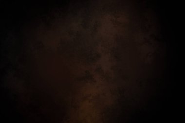 Takım elbiseli ve kravatlı bir adam karanlık bir arka planın önünde duruyor.