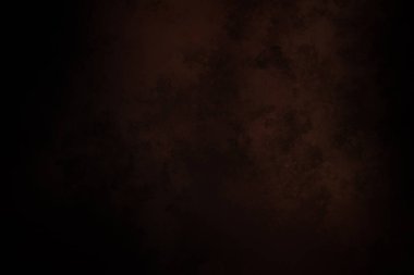 Takım elbiseli ve kravatlı bir adam karanlık bir arka planın önünde duruyor.