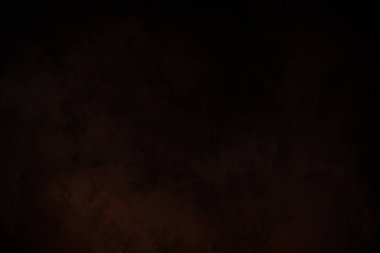 Takım elbiseli ve kravatlı bir adam ateşin önünde duruyor.