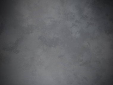 Gri bir duvarın önünde duran takım elbiseli ve kravatlı bir adam.