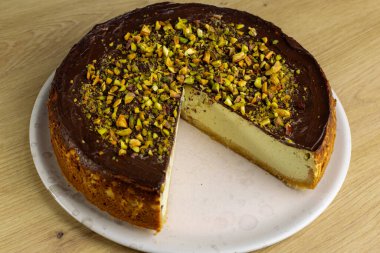 Ev yapımı fıstıklı cheesecake. Koyu çikolataya batırılmış.