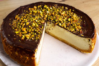 Ev yapımı fıstıklı cheesecake. Koyu çikolataya batırılmış.