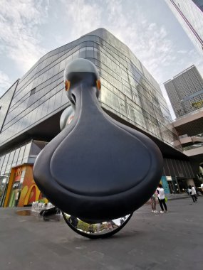 Çin, Shenzhen - 25 Ekim 2024: Modern bir alışveriş merkezinin önünde duran büyük, siyah, soyut bir kuş heykeli.