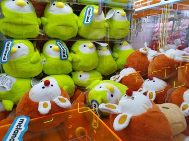 Çin, Shenzhen - 25 Ekim 2024: Parlak ışıklı bir alışveriş merkezinde peluş oyuncaklarla dolu bir pençe makinesi.