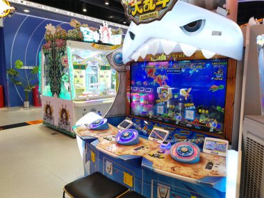 Çin, Shenzhen - 25 Ekim 2024: Bir alışveriş merkezinde açık ağızlı ve keskin dişli bir çizgi film köpekbalığının yer aldığı büyük bir atari oyunu.