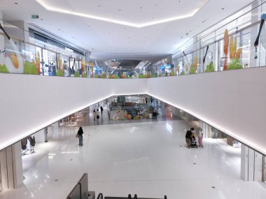 Çin, Shenzhen - 25 Ekim 2024: Çin 'de yüksek tavanlı, beyaz duvarlı ve parlak bir tasarımı olan modern bir alışveriş merkezinin içi.