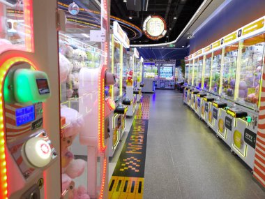 Çin, Shenzhen - 25 Ekim 2024: Shenzhen, Çin 'deki parlak, modern bir alışveriş merkezinde bir sıra pençe makinesi.