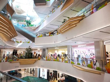 Çin, Shenzhen - 25 Ekim 2024: Çin 'deki modern bir alışveriş merkezinin içinde, yürüyen merdivenler, dükkanlar ve dekoratif fabrikalarla birden fazla katlı bir manzara.