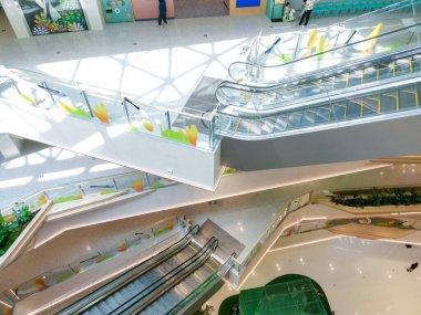Çin, Shenzhen - 25 Ekim 2024: Shenzhen, Çin 'de yürüyen merdiven ve geometrik desenli modern bir alışveriş merkezinin genel görünümü.
