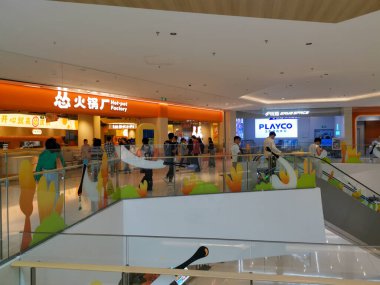 Çin, Shenzhen - 25 Ekim 2024: Çin 'de modern bir alışveriş merkezi manzarası. İnsanlar üst kattaki yiyecek tezgahlarının ve dükkanların önünden geçiyor..