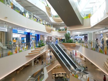 Çin, Shenzhen - 25 Ekim 2024: Çin 'de beyaz duvarlar, ahşap aksanlar ve bitkilerin yer aldığı bir sonraki seviyeye çıkan bir yürüyen merdivenle modern bir alışveriş merkezi.