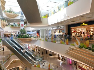 Çin, Shenzhen - 25 Ekim 2024: Yürüyen merdiveni, çok katlı ve perakende satış mağazaları olan modern bir alışveriş merkezi.