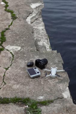 Siyah bir arka planı olan beyaz bir dron yerde yatıyor.