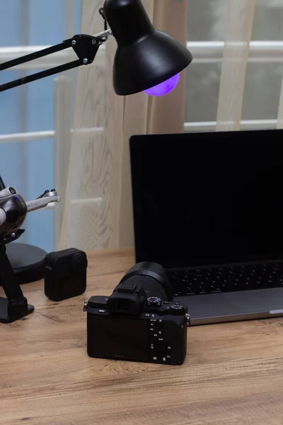 Modern ofis odasında dizüstü bilgisayarda çalışan profesyonel fotoğrafçı.
