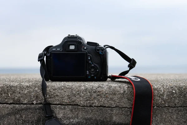 一个在海滩上拿着相机的摄影师的特写镜头 — 图库照片