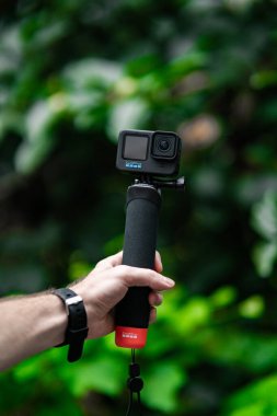 Elinde tripodla kamera tutan bir adam.