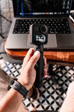 Adam ahşap masada kameralı akıllı drone kullanıyor.