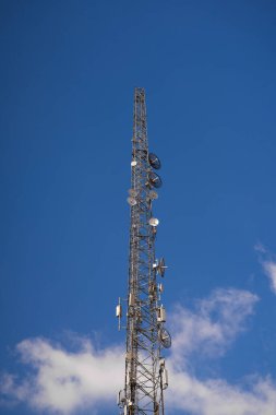Mavi gökyüzünde bulutlu cep telefonu kulesi