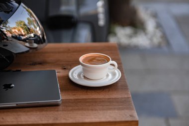 Masanın üzerinde açık bir defterde beyaz bir bilgisayarla sade kahve.