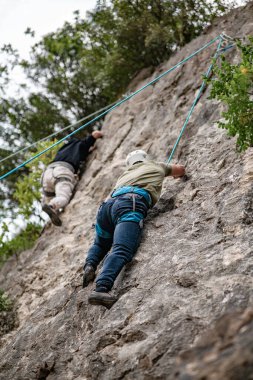 Erkek tırmanışçı kayadaki ipe tırmanıyor.