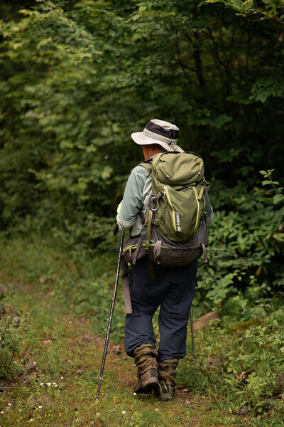 man with backpack hiking in mountains