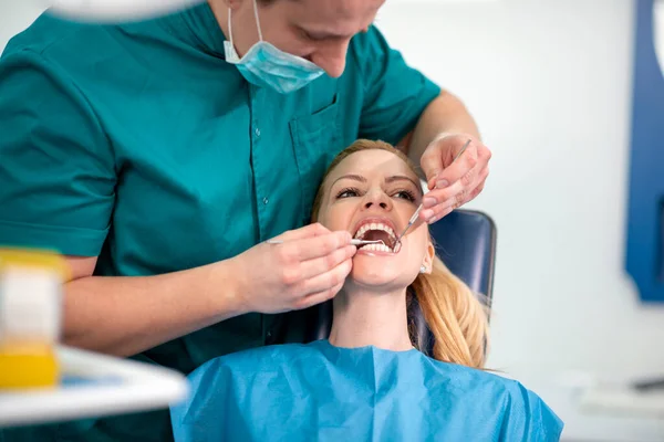 在牙科诊所检查病人牙齿的牙科医生 — 图库照片
