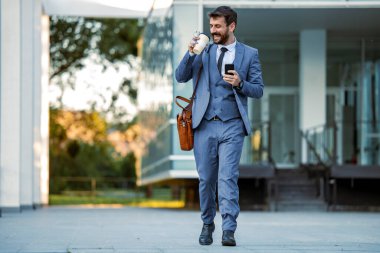 İş adamı ofisinin önünde cep telefonu kullanıyor. İnsanlar, iş ve iş kavramı.