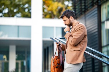 Sinirli iş adamı dijital tableti açık havada kullanıyor..