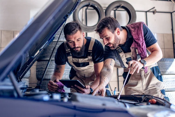 Young Auto Mechanics Using Digital Tablet While Repairing Car Engine — Stock Photo, Image