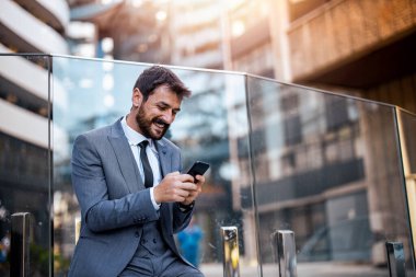 İş adamı ofisinin önünde cep telefonu kullanıyor. İnsanlar, iş ve iş kavramı.